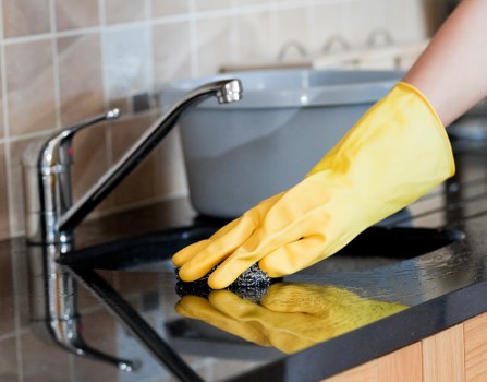 Cleaner treating a carpeted hallway in SW15 with hot water extraction equipment